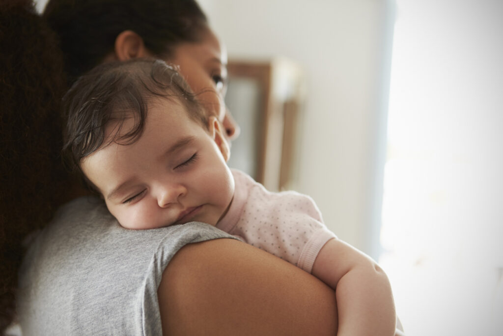 Baby sleeping on woman's shoulder