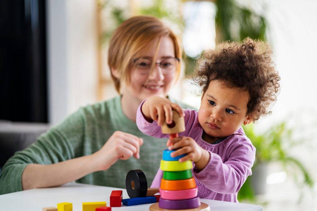 Woman supervising infant playing